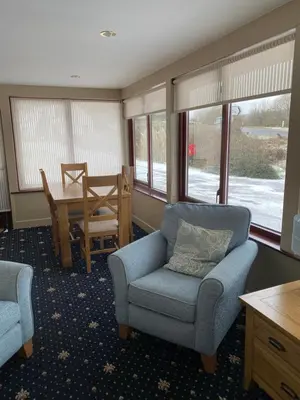 a living room with a couch and a chair and a table at West Loch House in West Tarbert