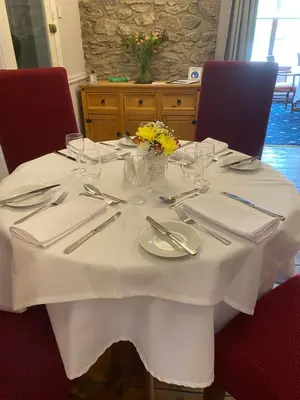 a table with a white table cloth and silverware at West Loch House in West Tarbert