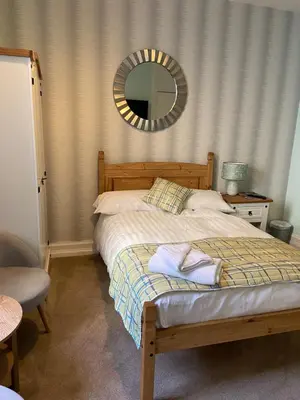 a bedroom with a bed with a mirror on the wall at West Loch House in West Tarbert