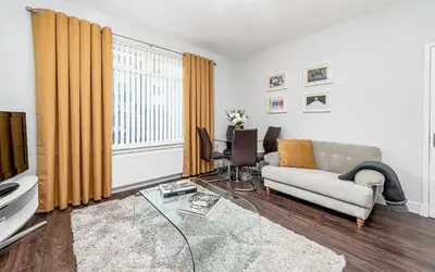 a living room with a couch and a tv at Balmoral Residence 30 mins from Edinburgh and Glasgow in Falkirk
