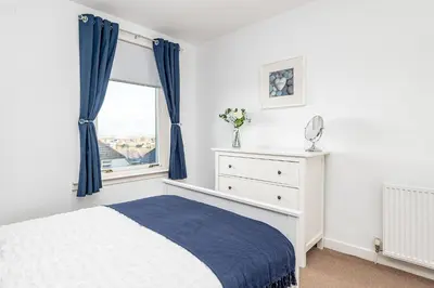 a bedroom with a bed and a window at Balmoral Residence 30 mins from Edinburgh and Glasgow in Falkirk