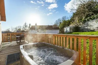 a hot tub on the deck of a house at Kestrel Lodge 6 with Hot Tub in Newton Stewart