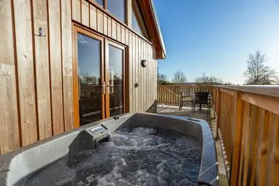 a hot tub on the side of a house at Kestrel Lodge 7 with Hot Tub in Newton Stewart