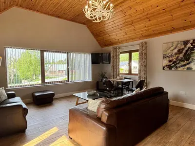 a living room with a couch and a table at Osprey Lodge 8 with Hot Tub in Newton Stewart