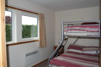 a bedroom with a bunk bed and two windows at The Old School in Dalavich
