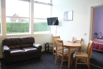 a living room with a couch and a table and a chair at The Old School in Dalavich