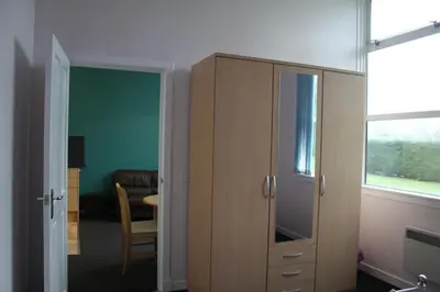 a room with a wooden cabinet and a dining room at The Old School in Dalavich