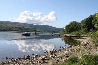 a body of water with boats and clouds in the water at The Old School in Dalavich