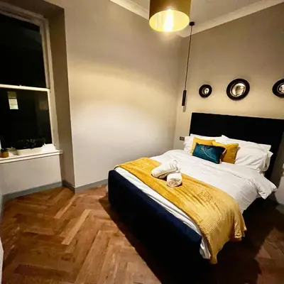 a bedroom with a bed with a yellow blanket on it at 1 bed Apt in West End in Glasgow