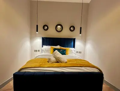 a bedroom with a large bed with a blue headboard at 1 bed Apt in West End in Glasgow