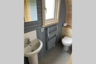 a bathroom with a sink and a toilet and a window at Sea Breeze Pod in Fort William