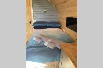 a bed in a tiny house with a tv at Sea Breeze Pod in Fort William