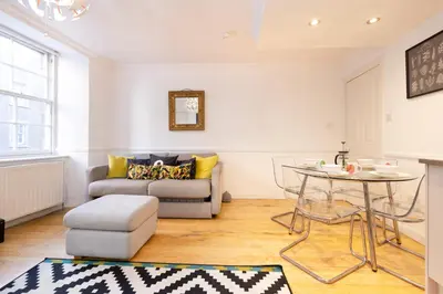 a living room with a couch and a table at JOIVY Charming Home with Patio Nearby the Castle in Edinburgh