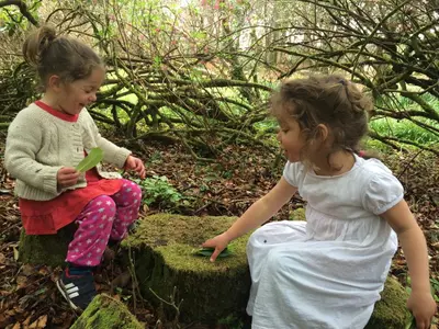 two little girls sitting on a rock in the woods at Bonawe House Holiday Cottages in Taynuilt