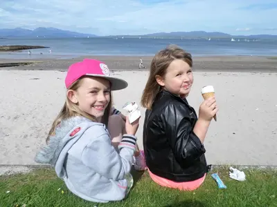two young girls eating ice cream at the beach at Bonawe House Holiday Cottages in Taynuilt