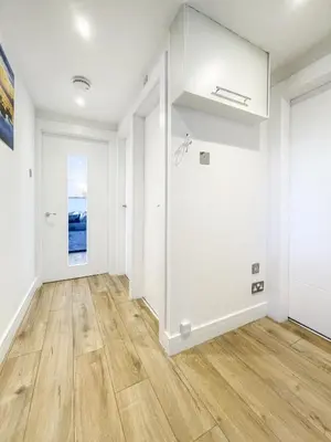 an empty living room with white walls and wooden floors at The Penthouse in Oban