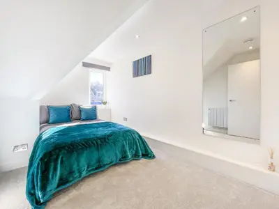 a bedroom with a green bed in a white room at The Penthouse in Oban
