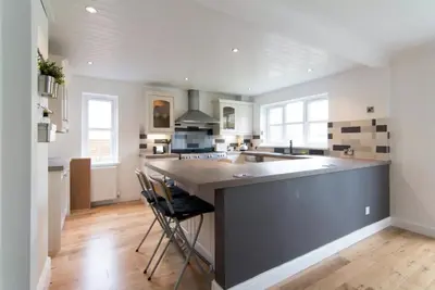 a large kitchen with a large island in the middle at Kilburn Holiday Cottage in Largs