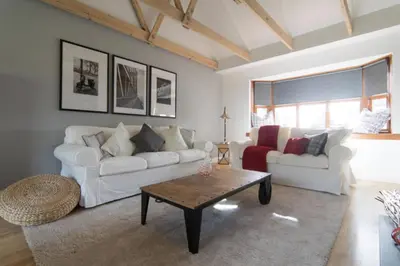 a living room with two white couches and a coffee table at Kilburn Holiday Cottage in Largs