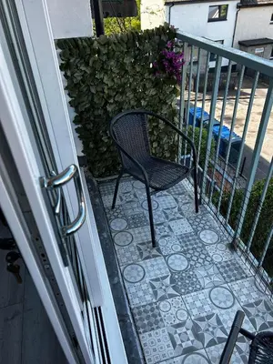 a patio with a chair on a balcony at Entire Modern Apartment in Oban with Balcony in Oban