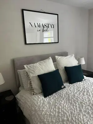 a bed with pillows and a picture on the wall at Entire Modern Apartment in Oban with Balcony in Oban