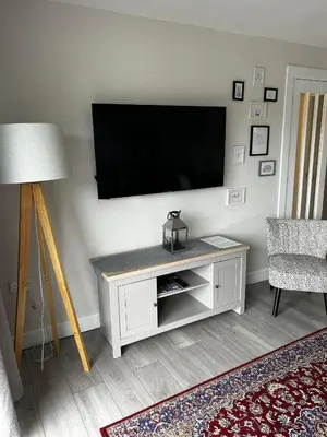 a living room with a flat screen tv on a wall at Entire Modern Apartment in Oban with Balcony in Oban