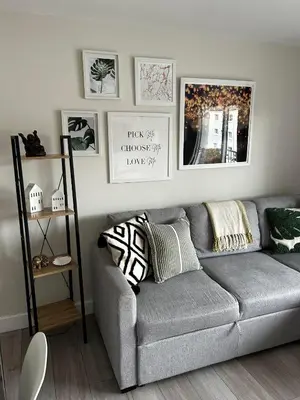 a living room with a gray couch and pictures on the wall at Entire Modern Apartment in Oban with Balcony in Oban