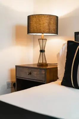 a bedroom with a bed with a lamp on a nightstand at City View - A Stunning 2 Bed Apartment in Glasgow