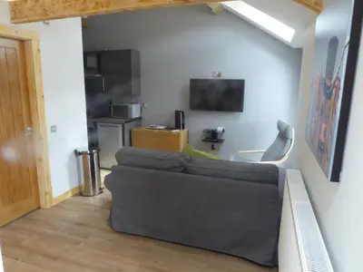 a living room with a couch and a television at Auchendennan Farm Self Catering Cottages in Balloch