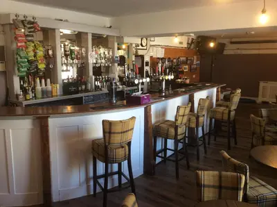 a bar with a bunch of bar stools at Queensberry arms hotel in Kirkconnel
