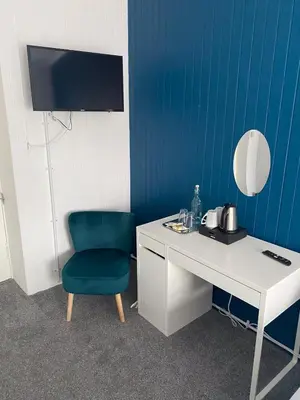 a desk with a green chair next to a blue wall at Queensberry arms hotel in Kirkconnel