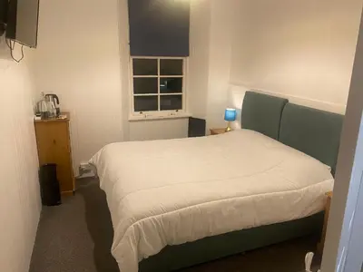 a bedroom with a bed in a room with a window at Queensberry arms hotel in Kirkconnel