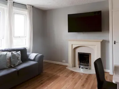 a living room with a couch and a fireplace at Cozy two bed flat near Glasgow Airport & Paisley - Pass the Keys in Paisley