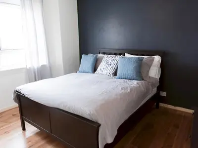 a bed with blue pillows on it in a bedroom at Cozy two bed flat near Glasgow Airport & Paisley - Pass the Keys in Paisley