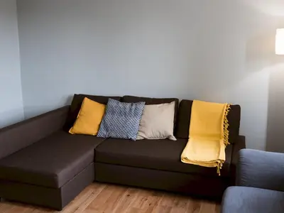 a couch with pillows on it in a living room at Cozy two bed flat near Glasgow Airport & Paisley - Pass the Keys in Paisley