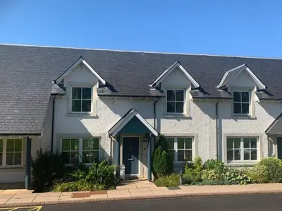a large white house with a black roof at Ryder Cup Lodge Duchally - Free access to Leisure Club Swimming Pool Hot Tub Steam Room - Starlink Satellite Internet - Sky Glass Now DOG FRIENDLY for 2025 in Auchterarder