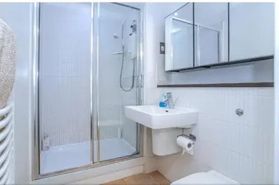 a white bathroom with a shower and a sink at Oswald Apartment - Glasgow City Centre in Glasgow