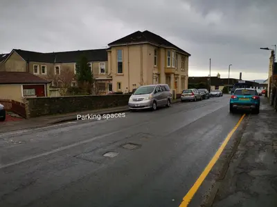 a street with cars parked on the side of the road at Welcome to St Helena Dunoon, a traditional villa in Dunoon