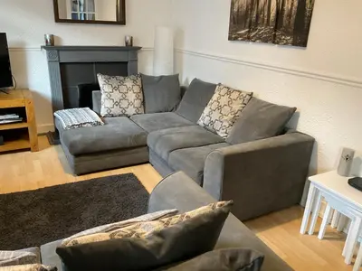 a living room with a gray couch and a fireplace at Glenashdale 28 A 1/R Boyd Street Largs KA308LE in Largs