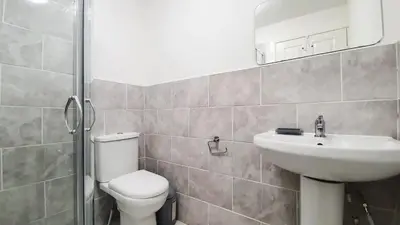 a bathroom with a toilet and a sink and a mirror at Bemersyde Guest House in Mansewood