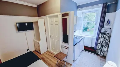 a small room with a door and a sink at Bemersyde Guest House in Mansewood