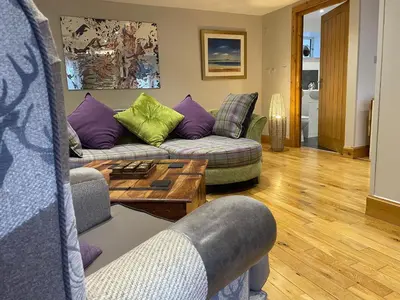 a living room with two couches and a coffee table at The Mews with Private Parking in Oban