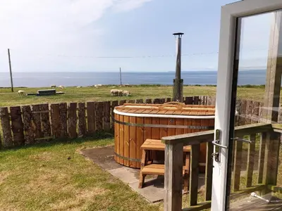 a hot tub in a yard with sheep in a field at North Muasdale Farm in Muasdale