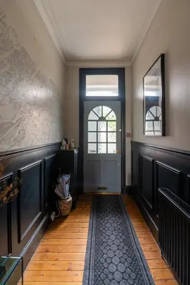 a hallway with a door and a wooden floor at Traditional apt close to city centre & Hampden in Glasgow