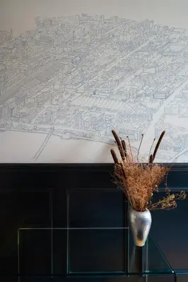 a vase on a table with a mural of a city at Traditional apt close to city centre & Hampden in Glasgow