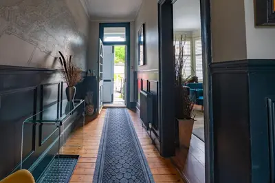 a hallway with a door and a tile floor at Traditional apt close to city centre & Hampden in Glasgow