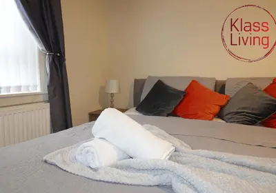 a rolled up white towel sitting on a bed at Welsh Drive Apartment by Klass Living Blantyre in High Blantyre