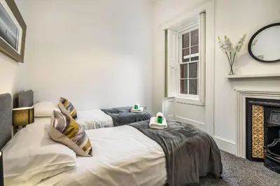 two beds in a room with a fireplace at Renfrew Residence Central Glasgow 4-Bed Flat in Glasgow