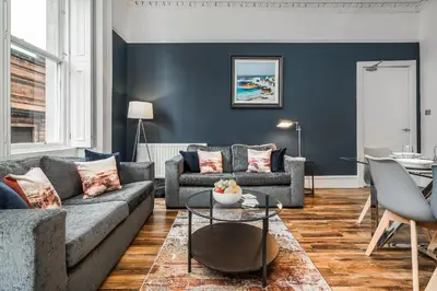 a living room with a couch and a table at Renfrew Residence Central Glasgow 4-Bed Flat in Glasgow