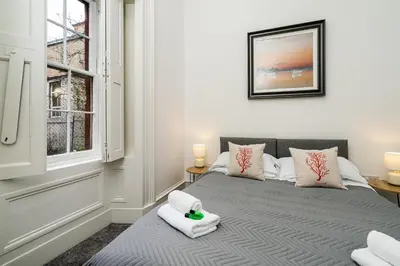 a bedroom with a bed with a teddy bear on it at Renfrew Residence Central Glasgow 4-Bed Flat in Glasgow
